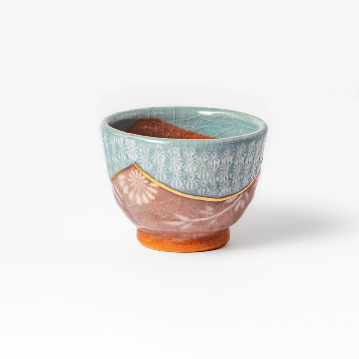 Ceramic tea cup featuring a crackled turquoise glaze with floral patterns and a contrasting earthy brown base for a handcrafted look.