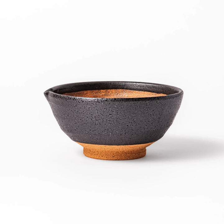 Black ceramic suribachi mortar bowl with rough-textured brown interior grooves and spout, ideal for grinding sesame seeds and other seasonings with precision.