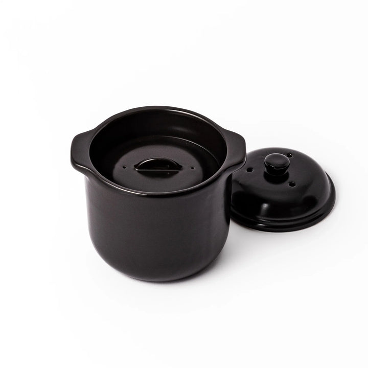 Black ceramic microwave rice cooker with double lid and side handles, designed for convenient cooking and serving at the table.