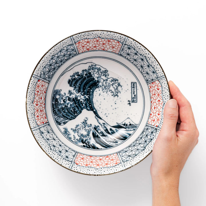 Japanese porcelain ramen bowl featuring Hokusai Great Wave design with red and blue geometric patterns in traditional style.