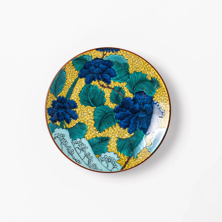 Porcelain dessert plate with bold blue peony flowers, green leaves, and a golden yellow background accented by intricate dot patterns.