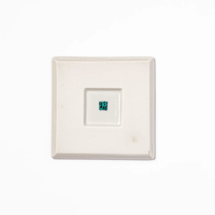 Square blue Japanese ceramic coaster with delicate white sakura blossoms and scattered petals, perfect for traditional dining settings.
