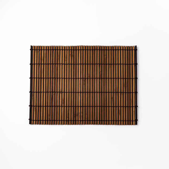 Brown bamboo table mat featuring alternating dark and natural slats bound with black cord, perfect for warm, earthy Japanese-inspired table settings.