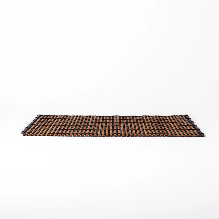 Brown bamboo table mat featuring alternating dark and natural slats bound with black cord, perfect for warm, earthy Japanese-inspired table settings.