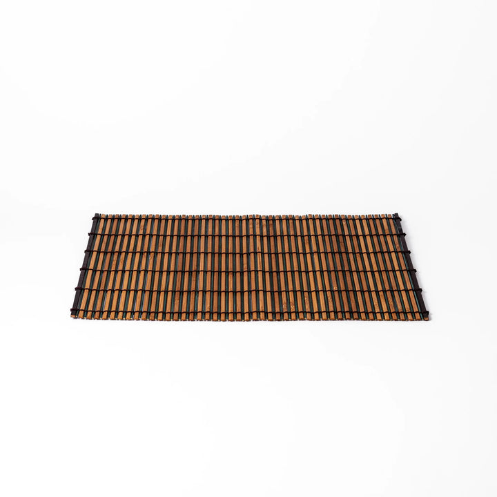Brown bamboo table mat featuring alternating dark and natural slats bound with black cord, perfect for warm, earthy Japanese-inspired table settings.