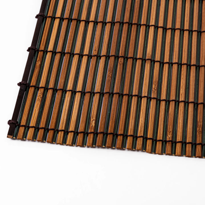 Brown bamboo table mat featuring alternating dark and natural slats bound with black cord, perfect for warm, earthy Japanese-inspired table settings.