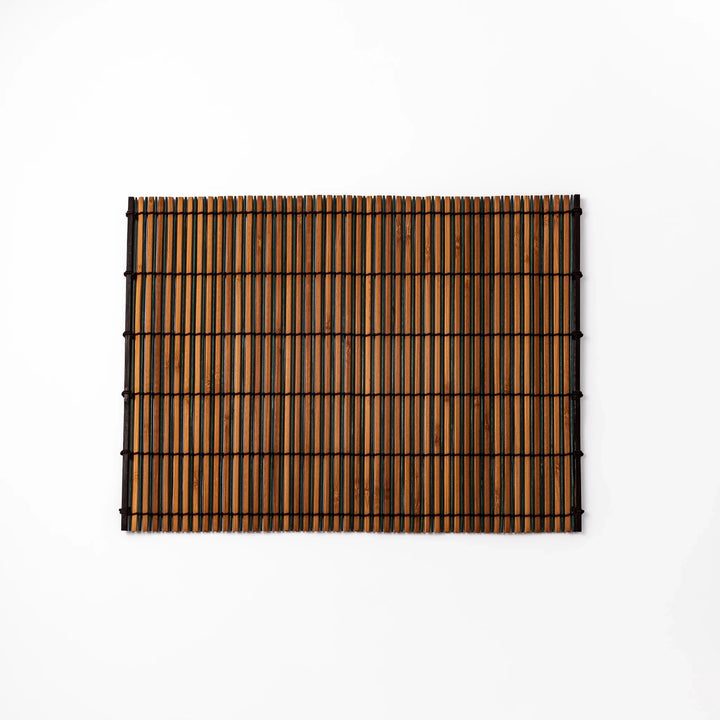 Brown bamboo table mat featuring alternating dark and natural slats bound with black cord, perfect for warm, earthy Japanese-inspired table settings.