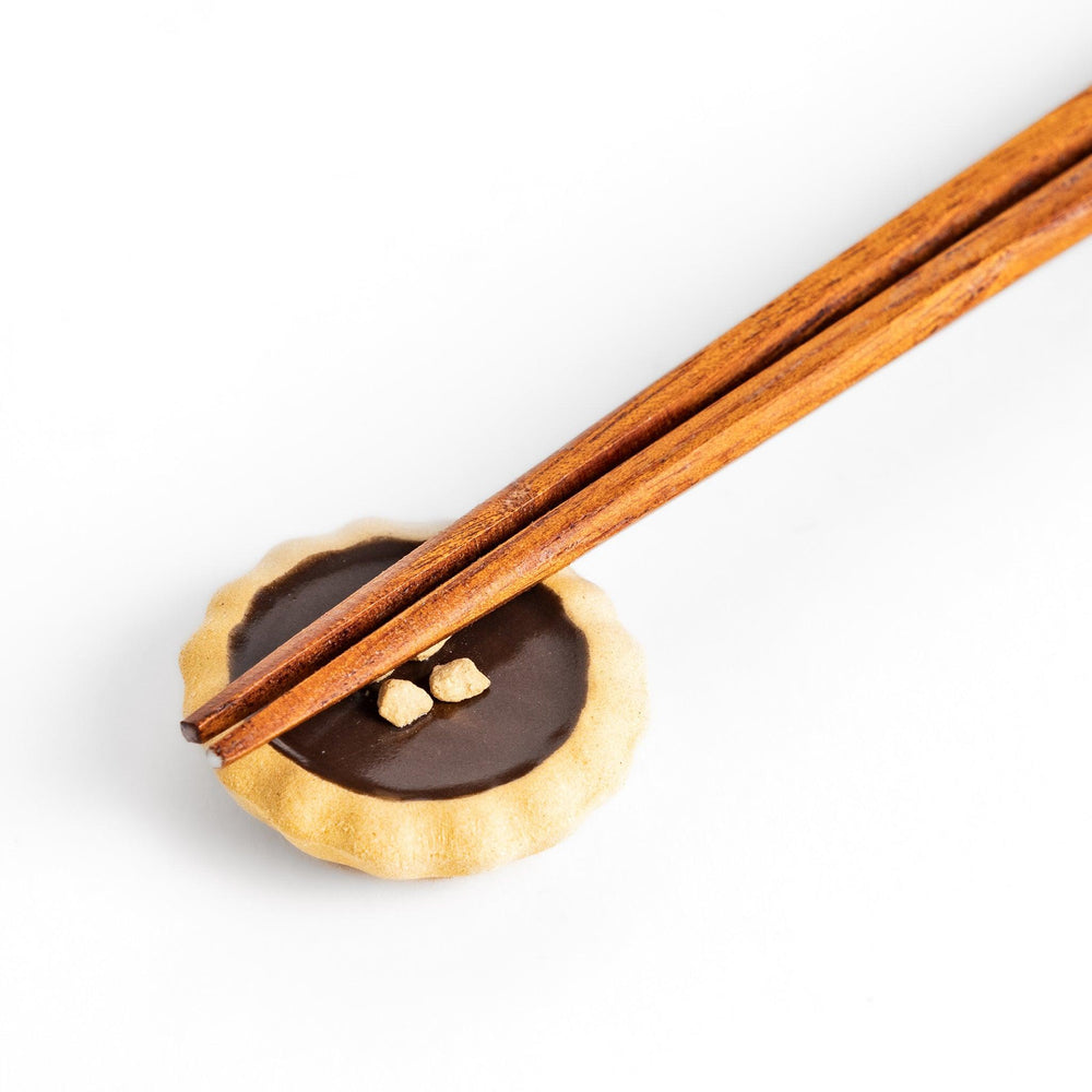 Deliciously detailed chocolate tart-shaped chopstick rest with a crumbly crust and chocolate filling, adding a sweet touch to your dining experience.