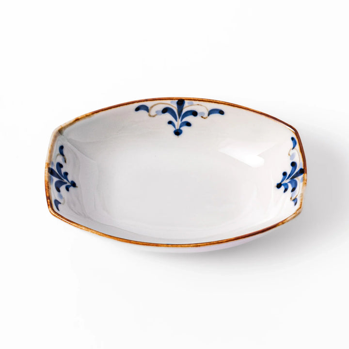 White boat-shaped bowl with blue floral patterns on the inner rim and a rustic brown edge, perfect for cereal or side dishes.