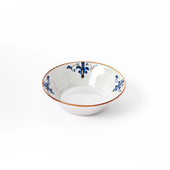 White dessert bowl with vertical ridges, blue floral accents around the rim, and a warm brown edge, perfect for sweets or fruit.