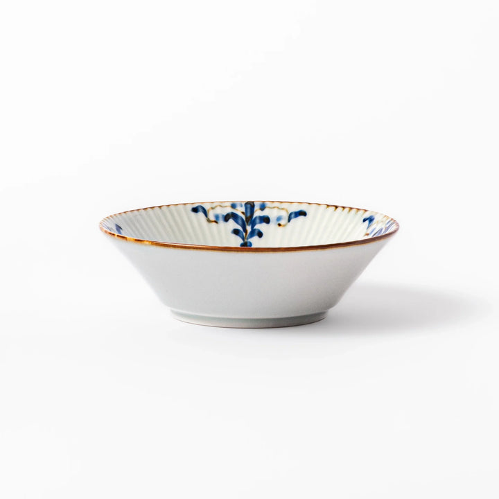 White dessert bowl with vertical ridges, blue floral accents around the rim, and a warm brown edge, perfect for sweets or fruit.
