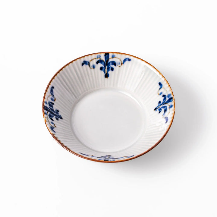 White dessert bowl with vertical ridges, blue floral accents around the rim, and a warm brown edge, perfect for sweets or fruit.
