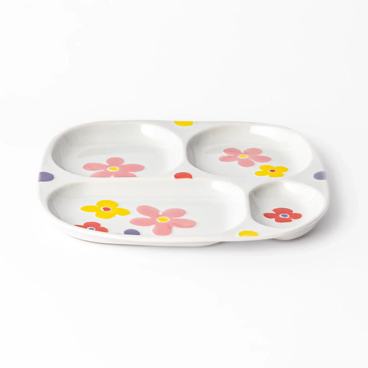 White ceramic kids plate with four divided sections, decorated with pink, yellow, red, and purple flower motifs