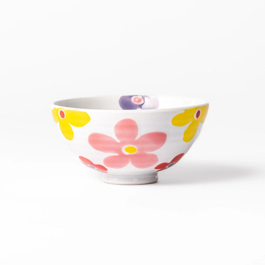 White ceramic kids rice bowl with pink, yellow, red, and purple flower motifs, round footed base