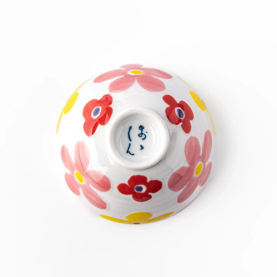 White ceramic kids rice bowl with pink, yellow, red, and purple flower motifs, round footed base