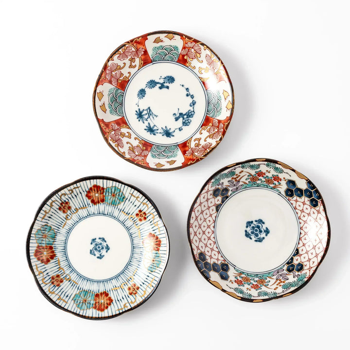 Set of three scalloped Japanese dessert plates featuring traditional patterns in red, blue, and gold, perfect for elegant sweets or small appetizers.
