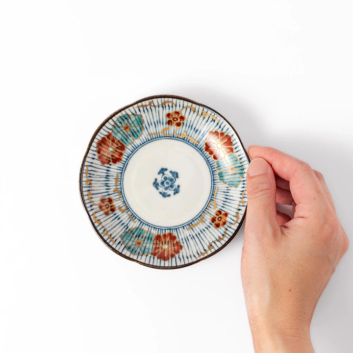 Scalloped edge Japanese sauce dish with vertical blue stripes and red, teal, and gold floral motifs, ideal for serving condiments with elegance.