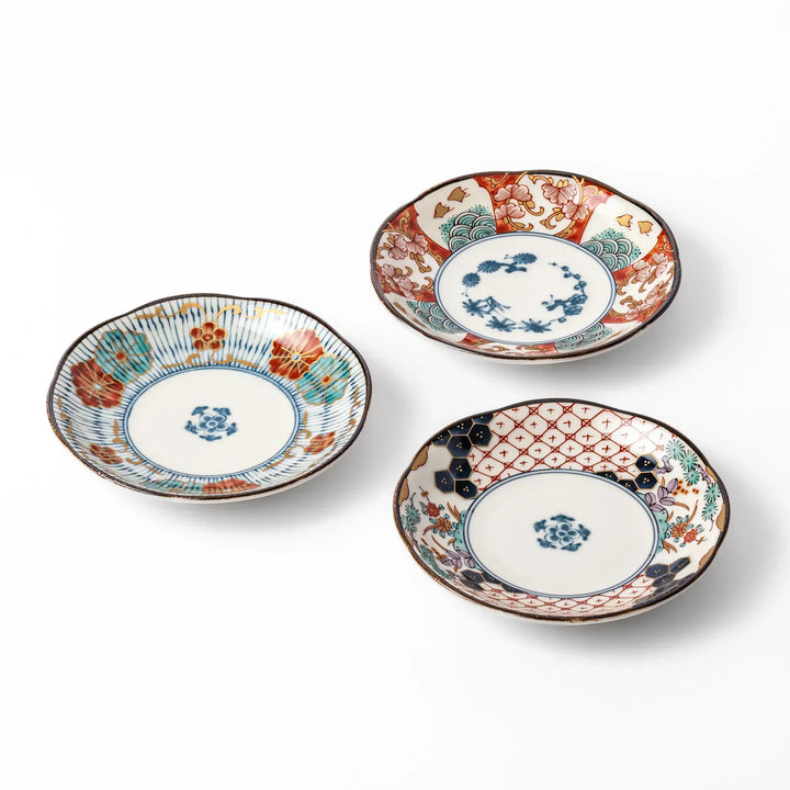 Set of three scalloped Japanese sauce dishes with intricate red, blue, and gold floral patterns, perfect for elegant condiments or small bites.