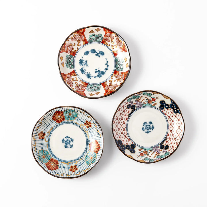 Set of three scalloped Japanese sauce dishes with intricate red, blue, and gold floral patterns, perfect for elegant condiments or small bites.