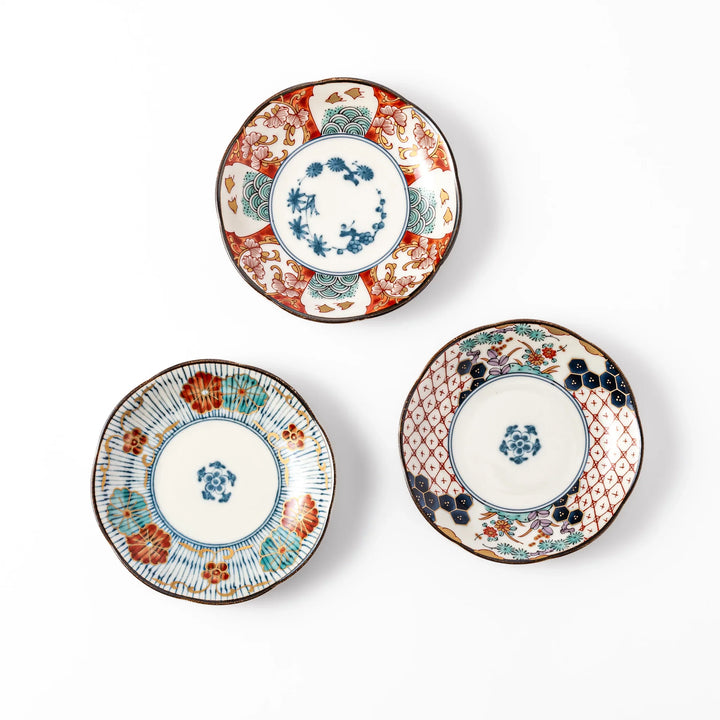 Set of three scalloped Japanese sauce dishes with intricate red, blue, and gold floral patterns, perfect for elegant condiments or small bites.