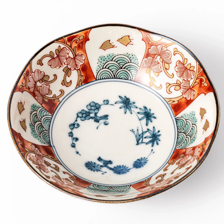 Scalloped Japanese dessert bowl with vibrant red, green, and gold patterns and a blue floral center, ideal for elegant traditional table settings.