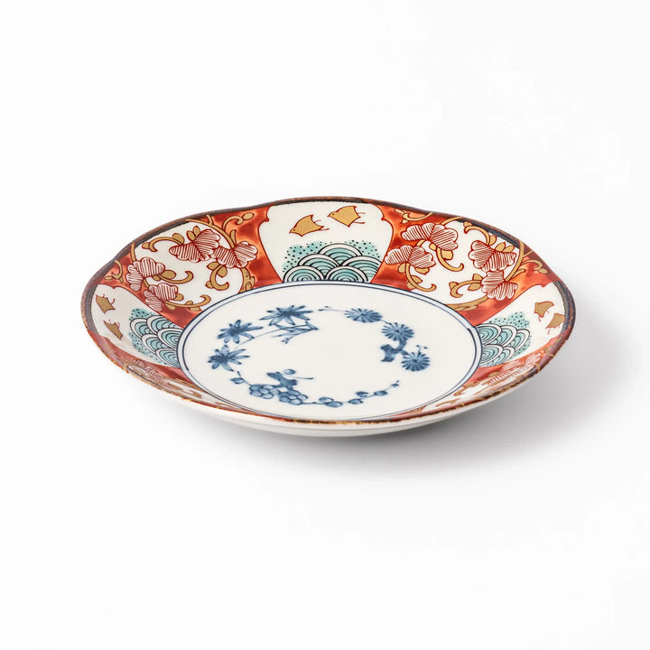 Elegant Japanese dessert plate with a scalloped edge, blue floral center, and red, gold, and green traditional patterns perfect for refined table settings.