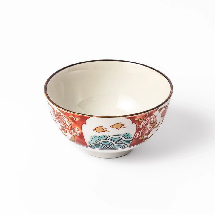 Traditional Japanese rice bowl featuring red, green, and gold motifs with waves, florals, and flying birds—perfect for refined, elegant dining.