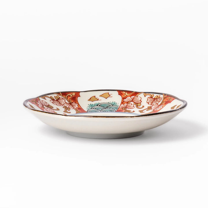 Scalloped edge sauce dish featuring red, blue, and green traditional Japanese motifs with a floral center, perfect for elegant table presentations.