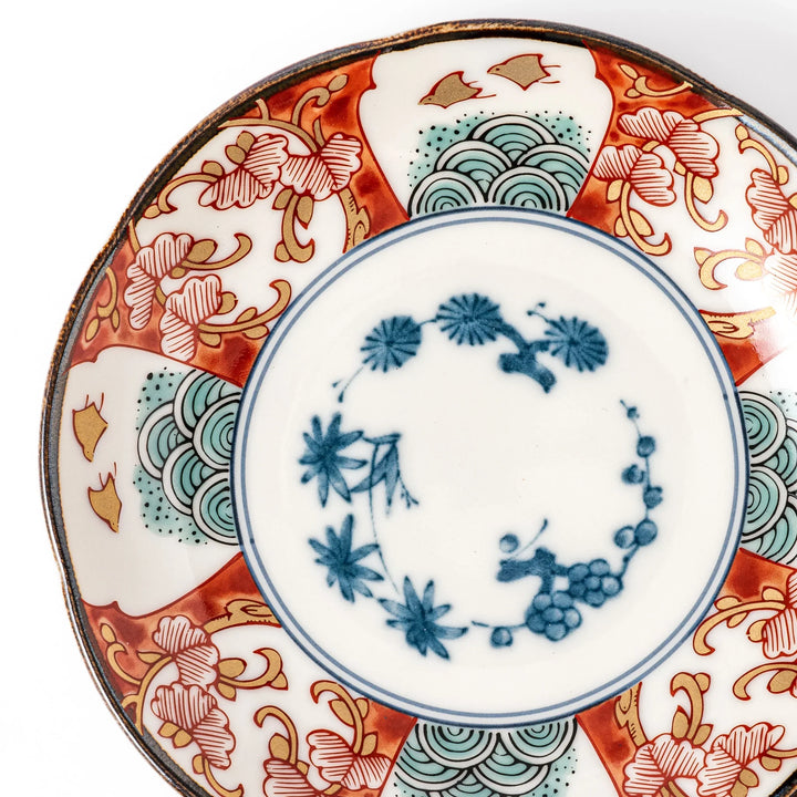 Scalloped edge sauce dish featuring red, blue, and green traditional Japanese motifs with a floral center, perfect for elegant table presentations.