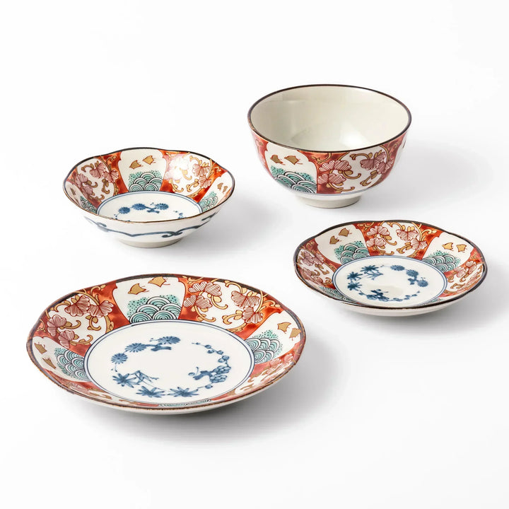 Set of traditional Japanese dishes with red, blue, and green motifs, featuring scalloped edges and floral wave patterns for elegant table settings.