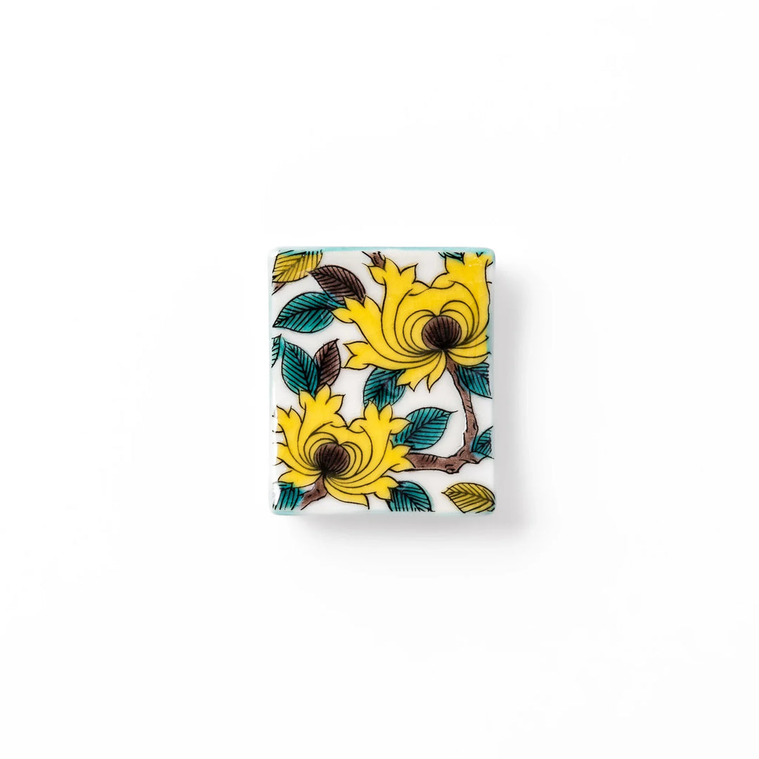 Japanese porcelain chopstick rest with yellow peony and teal leaf motif, hand-painted in traditional Kutani ware style.