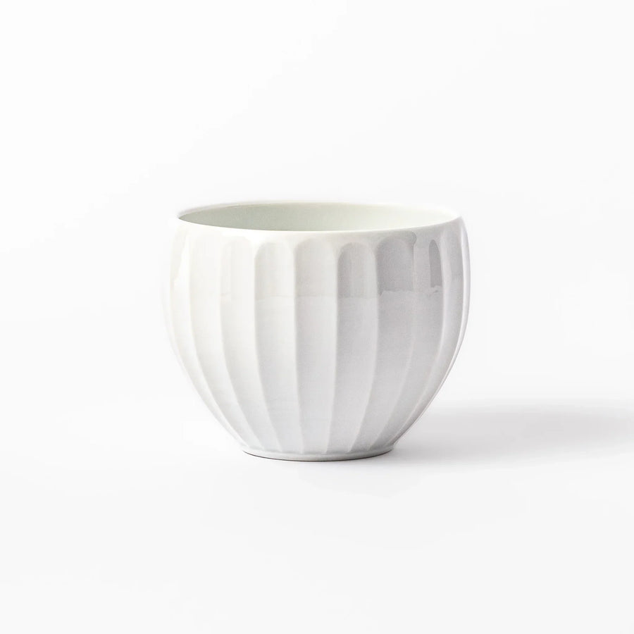 White teacup with vertical petal-like grooves and glossy finish, ideal for serving hot tea with a refined and modern aesthetic.