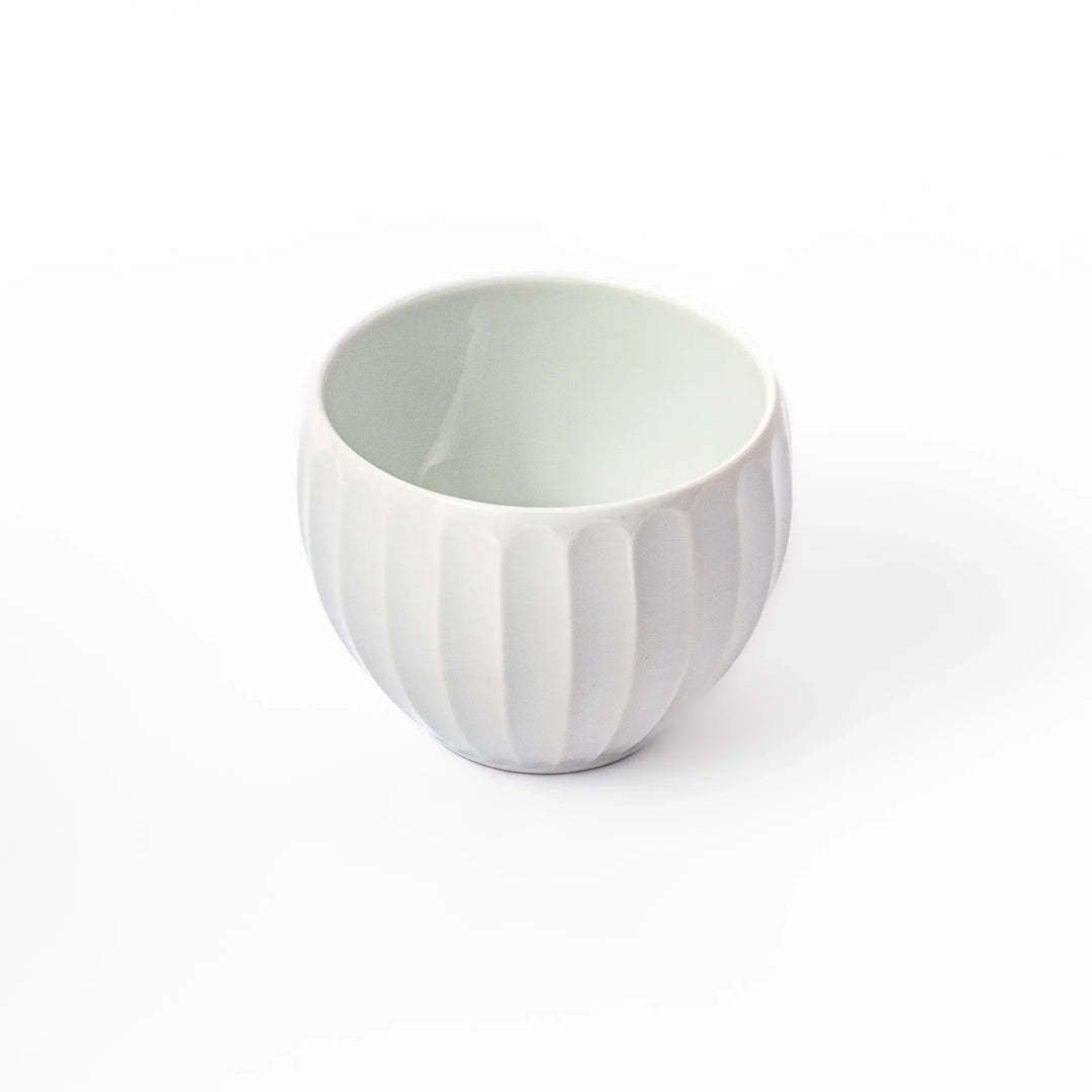 White teacup with vertical petal-like grooves and glossy finish, ideal for serving hot tea with a refined and modern aesthetic.