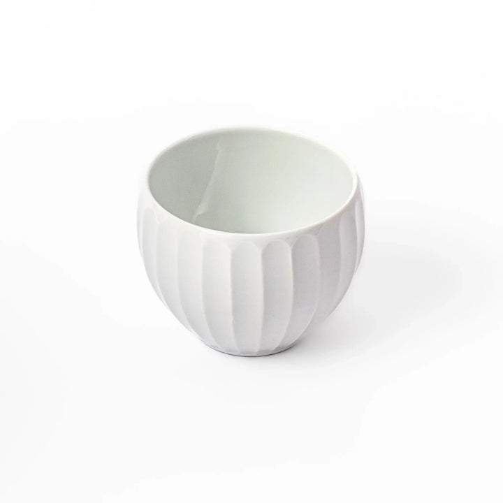 White teacup with vertical petal-like grooves and glossy finish, ideal for serving hot tea with a refined and modern aesthetic.