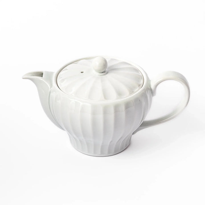 White teapot with vertical petal-inspired ridges and a round lid, perfect for a refined and elegant tea presentation.