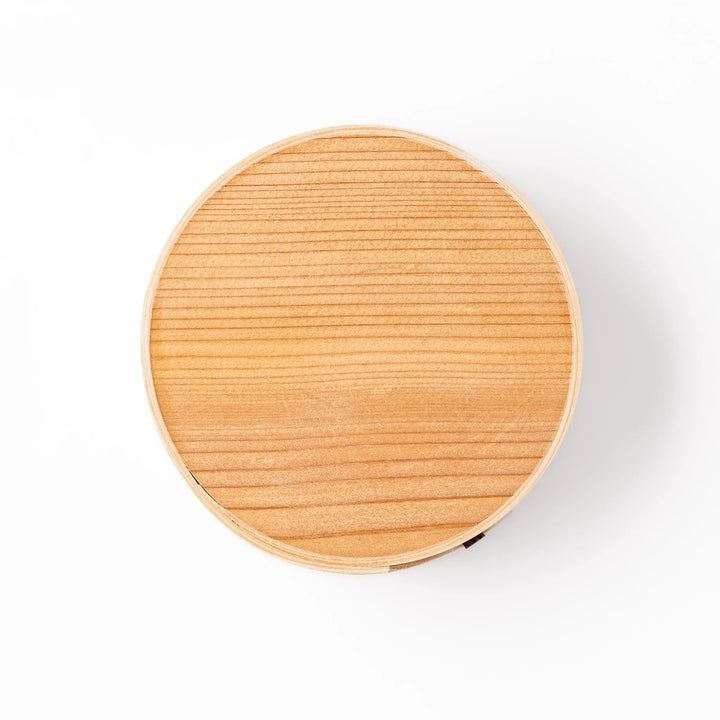 Round bento box handcrafted from natural hinoki wood with traditional magewappa joinery, ideal for packing Japanese-style lunches with elegance and aroma.