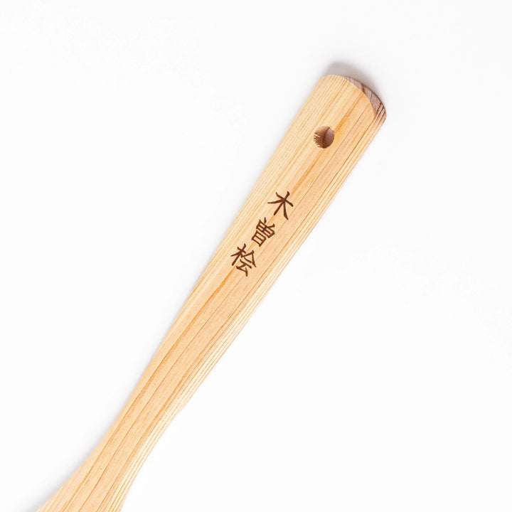 Compact hinoki wood spatula with a flat, angled edge and engraved handle, perfect for straining, flipping, and serving delicate dishes.