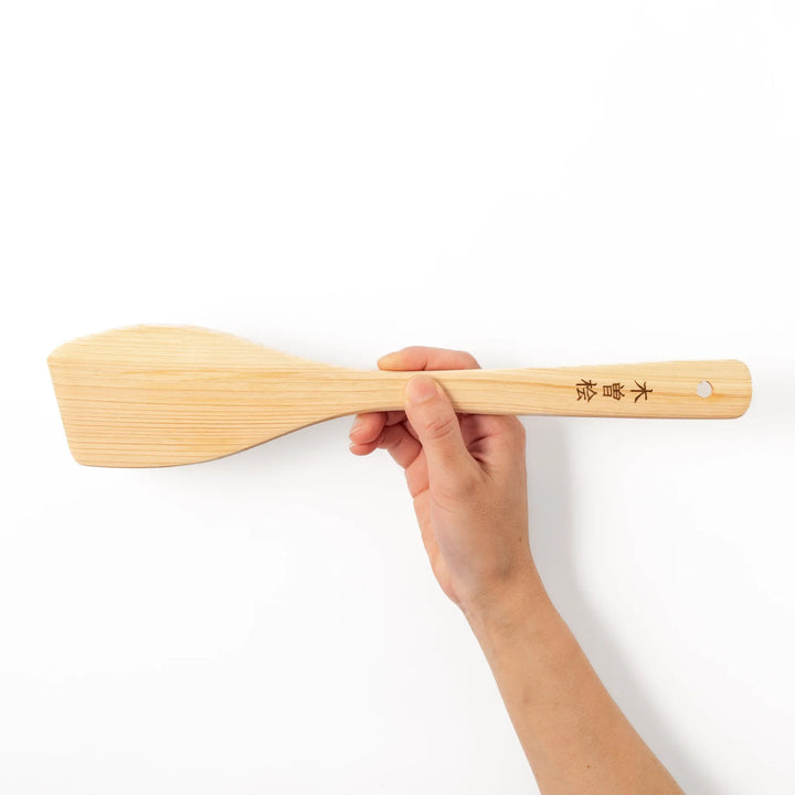 Compact hinoki wood spatula with a flat, angled edge and engraved handle, perfect for straining, flipping, and serving delicate dishes.