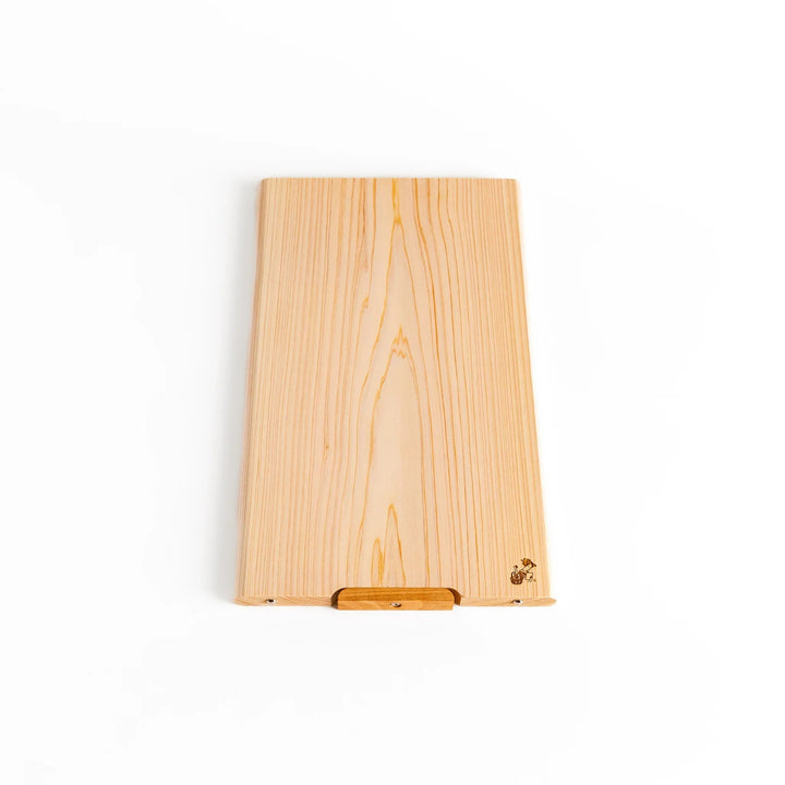 Hinoki wood cutting board with natural grain, engraved logo, and attached base for upright storage, combining beauty with everyday function.