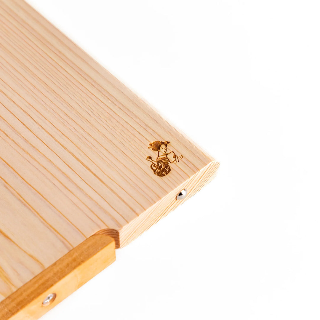 Hinoki wood cutting board with natural grain, engraved logo, and attached base for upright storage, combining beauty with everyday function.