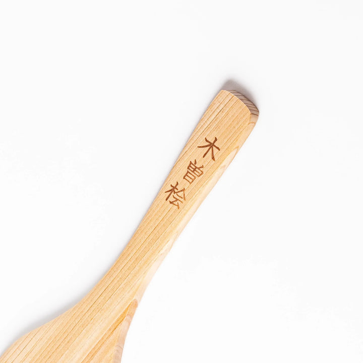 Compact hinoki wood spatula with a flat, angled edge and engraved handle, perfect for straining, flipping, and serving delicate dishes.