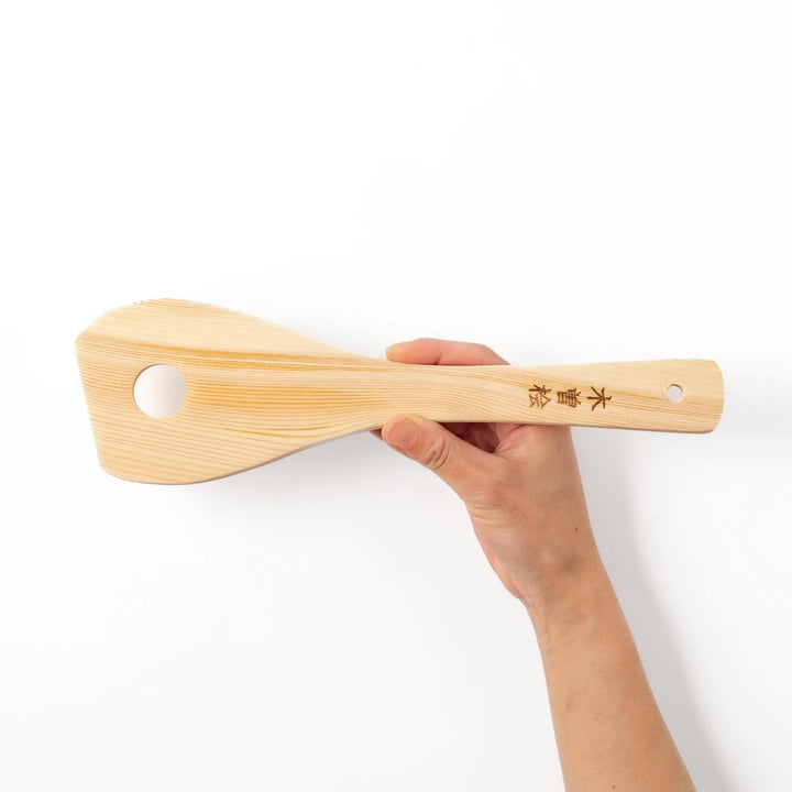 Hinoki wood slotted spatula with a circular cut-out and engraved handle, ideal for stirring and draining while adding a traditional Japanese touch.