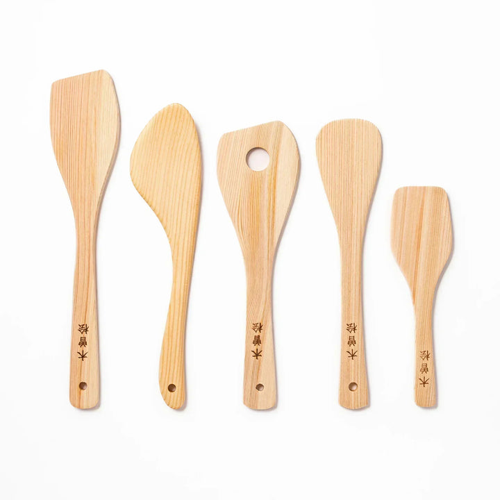 Set of five hinoki wood spatulas in assorted shapes, each with engraved Japanese characters, ideal for stir-frying and gentle cooking on nonstick surfaces.