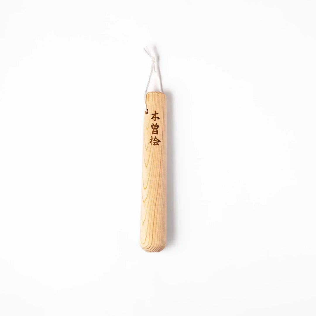 Hinoki wood pestle with engraved Japanese characters and hanging cord, crafted for use with suribachi mortars to grind seeds and spices smoothly.
