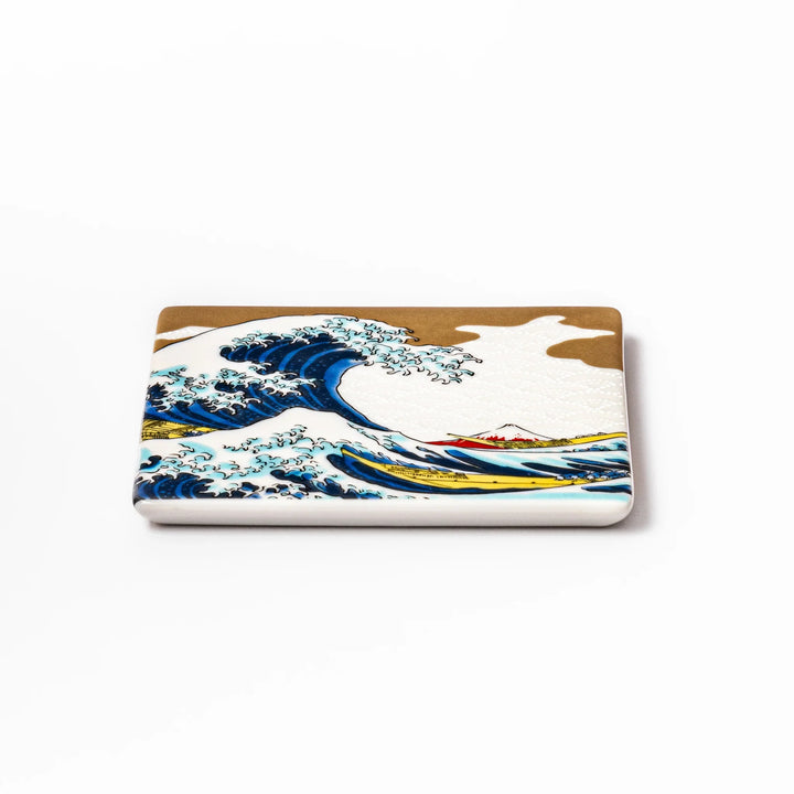 Square Japanese ceramic coaster featuring Hokusai’s Great Wave design with dramatic blue waves, golden sky, and Mt. Fuji, bringing iconic art to dining tables.
