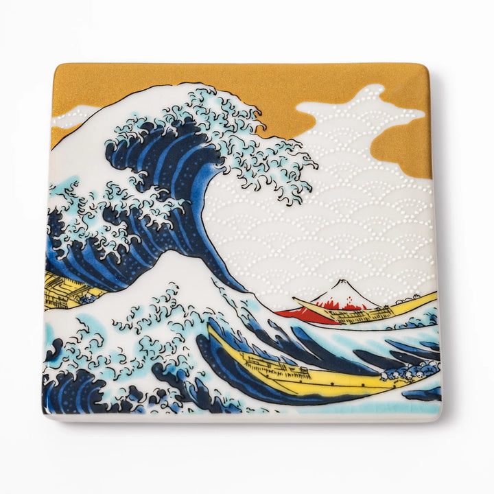Square Japanese ceramic coaster featuring Hokusai’s Great Wave design with dramatic blue waves, golden sky, and Mt. Fuji, bringing iconic art to dining tables.