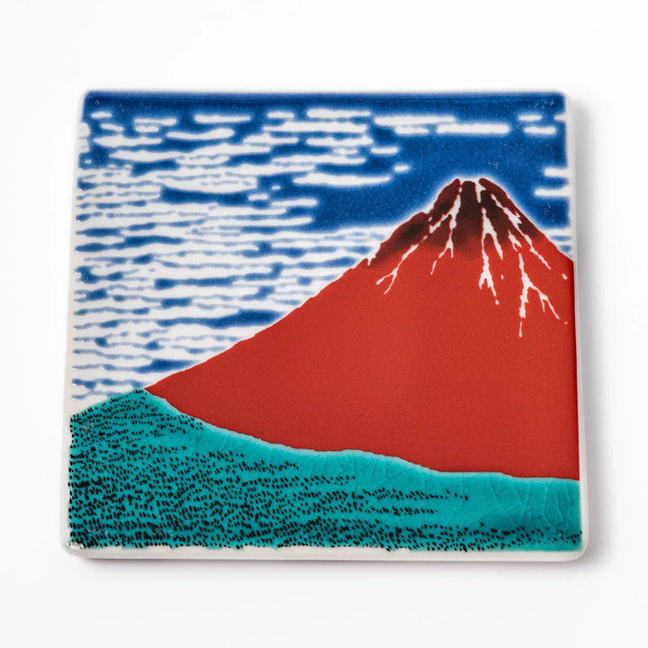 Square Japanese ceramic coaster featuring Hokusai’s Red Fuji design with vivid red mountain, blue sky, and clouds, adding iconic artistry to dining tables.