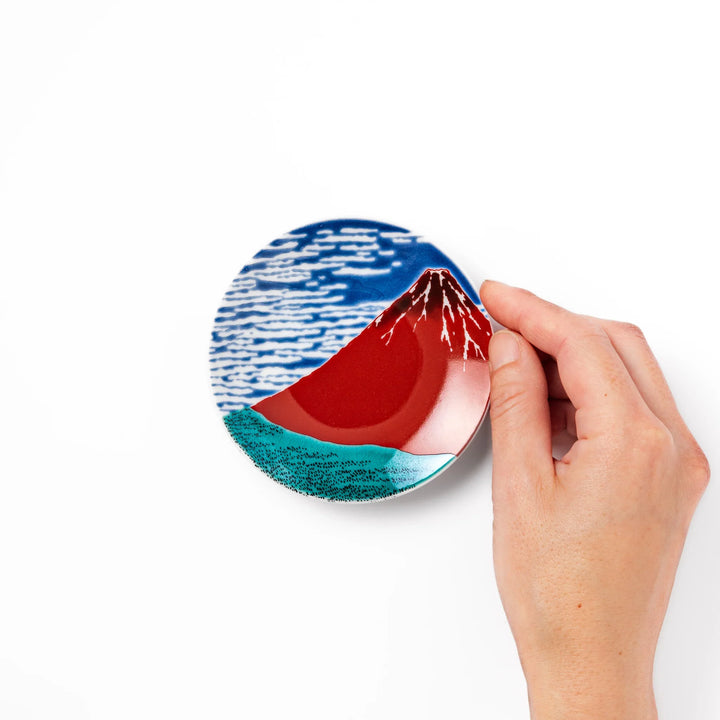 Round Japanese ceramic sauce dish featuring Hokusai’s iconic Red Fuji design with vivid red mountain, blue sky, and clouds, perfect for soy sauce or condiments.
