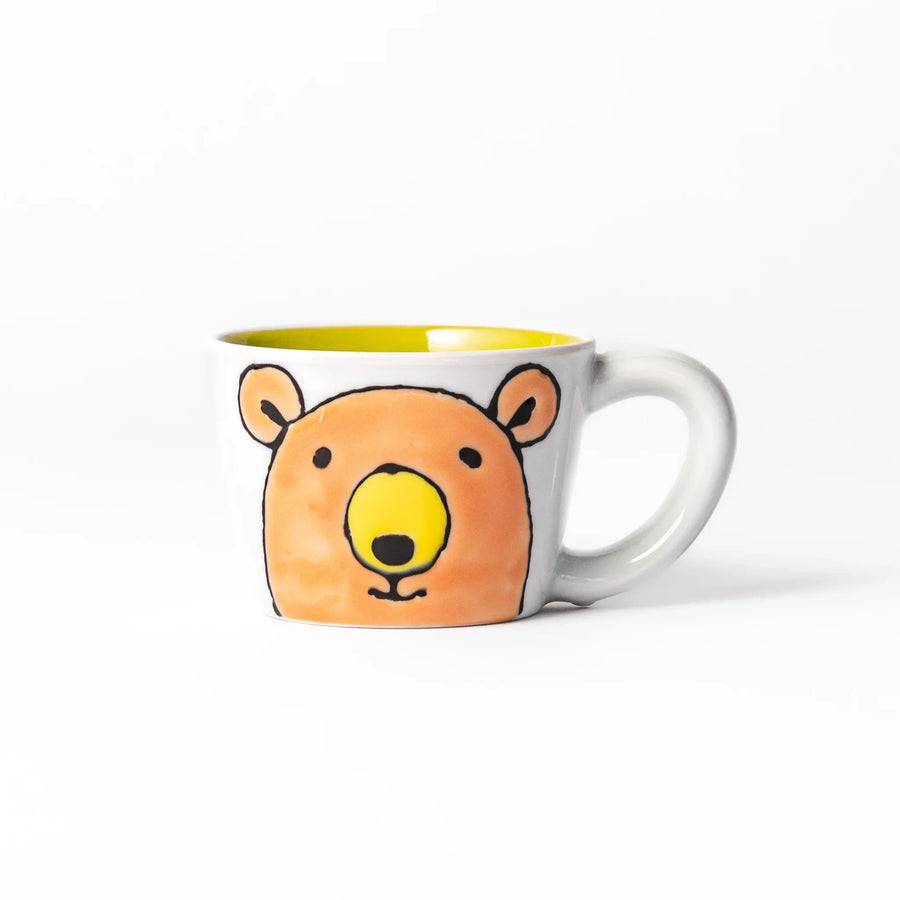 White ceramic kids mug featuring friendly honey bear face, yellow interior, round handle, shown on white background