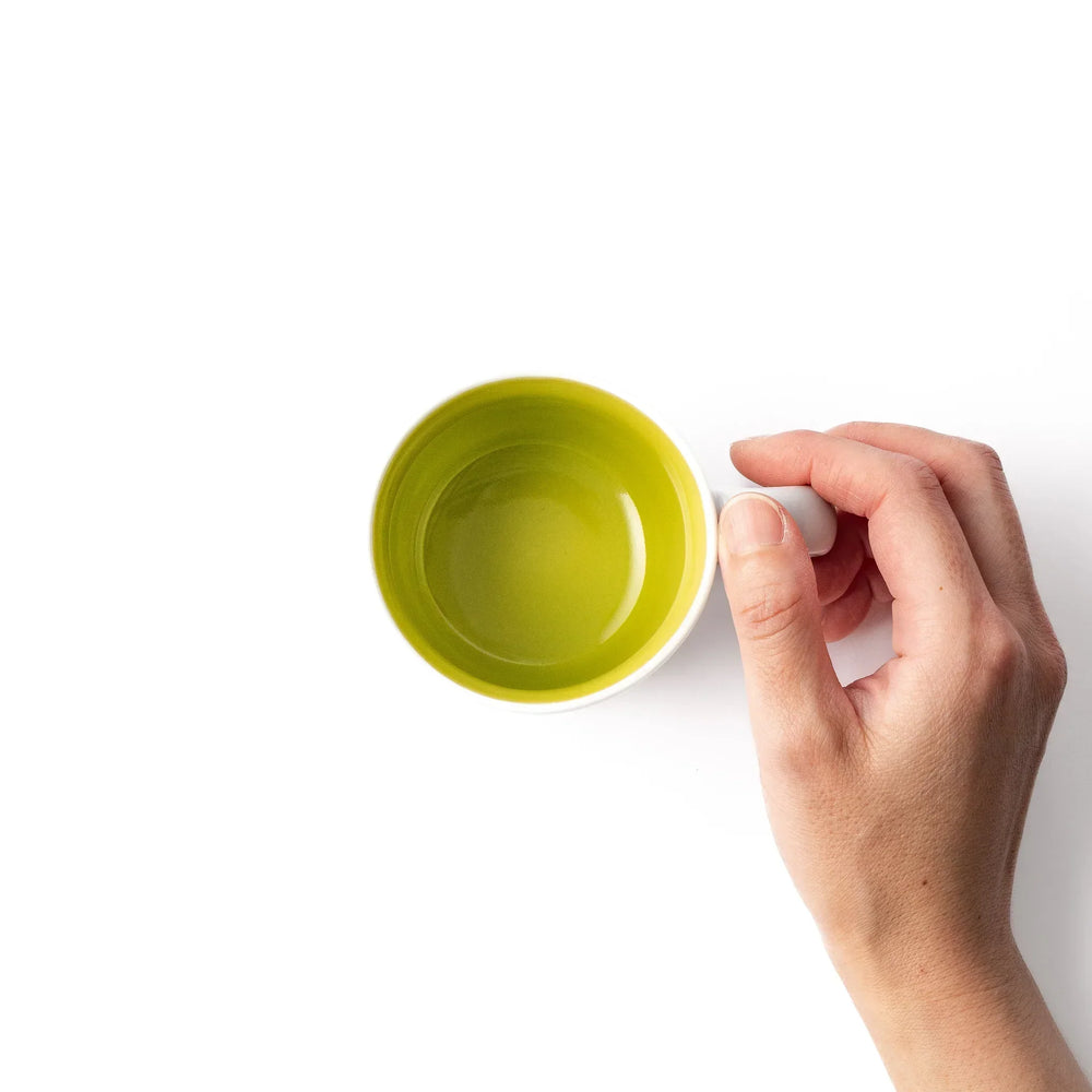 White ceramic kids mug featuring friendly honey bear face, yellow interior, round handle, shown on white background